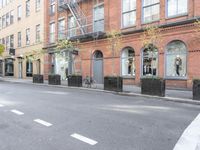 the cars are passing by the buildings on the street of the city streets as people walk near by
