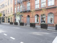 the cars are passing by the buildings on the street of the city streets as people walk near by