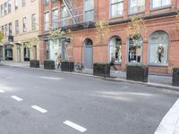 the cars are passing by the buildings on the street of the city streets as people walk near by