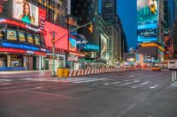 city street intersection with lights and buildings at night time in new york city, usa