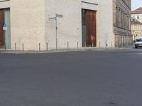 a person in red shirt riding a skateboard in street in city area with buildings and cars on pavement