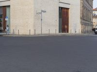 a person in red shirt riding a skateboard in street in city area with buildings and cars on pavement