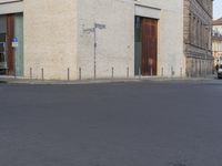 a person in red shirt riding a skateboard in street in city area with buildings and cars on pavement