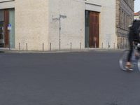 a person in red shirt riding a skateboard in street in city area with buildings and cars on pavement