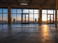 a room filled with glass windows and panes looking at the city at sunset during winter