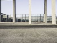 a man sitting on a bench in a parking lot near some glass windows in a building