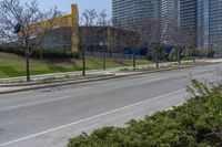 the side of a road has trees near by it and several buildings and a bicycle