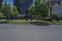 a tree lined street near a few high rise apartment buildings in the city of vancouver