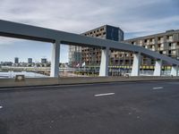 this is a view of a bridge over a river with an apartment building in the background