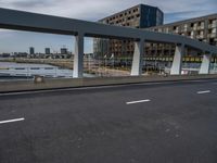 this is a view of a bridge over a river with an apartment building in the background