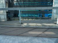 an empty parking lot with a glass building in the background and stairs on either side