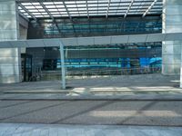 an empty parking lot with a glass building in the background and stairs on either side