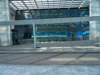 an empty parking lot with a glass building in the background and stairs on either side