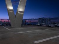 the large sculpture is in front of a city view at night, with two buildings to the left of it