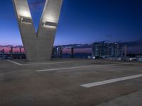 the large sculpture is in front of a city view at night, with two buildings to the left of it