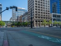 an empty street with buildings and parked cars on the sidewalks and green lanes on the sidewalk