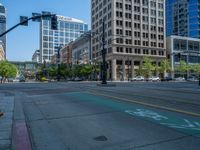 an empty street with buildings and parked cars on the sidewalks and green lanes on the sidewalk