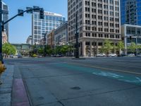 an empty street with buildings and parked cars on the sidewalks and green lanes on the sidewalk