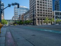 an empty street with buildings and parked cars on the sidewalks and green lanes on the sidewalk
