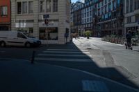 the sun shines on a deserted street as cars drive by on the street in the city