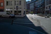 the sun shines on a deserted street as cars drive by on the street in the city