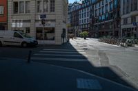 the sun shines on a deserted street as cars drive by on the street in the city