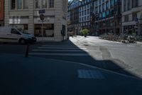 the sun shines on a deserted street as cars drive by on the street in the city