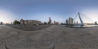 a fish eye lens has taken a photo of a view of buildings and water with a large bridge