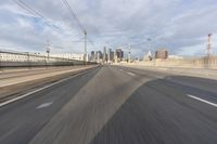 a view of an empty road through the front windshield of a car going over a bridge