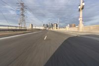 a view of an empty road through the front windshield of a car going over a bridge