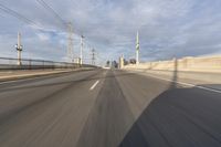 a view of an empty road through the front windshield of a car going over a bridge