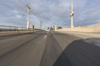 a view of an empty road through the front windshield of a car going over a bridge