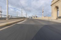 a view of an empty road through the front windshield of a car going over a bridge