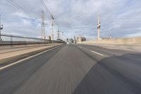 a view of an empty road through the front windshield of a car going over a bridge