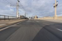 a view of an empty road through the front windshield of a car going over a bridge