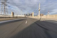 a view of an empty road through the front windshield of a car going over a bridge