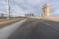 a view of an empty road through the front windshield of a car going over a bridge