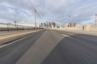 a view of an empty road through the front windshield of a car going over a bridge