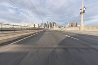 a view of an empty road through the front windshield of a car going over a bridge