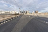 a view of an empty road through the front windshield of a car going over a bridge