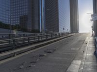 the sun is setting on a very big city skyline in the afternoon sun reflects off the glass windows and sidewalk