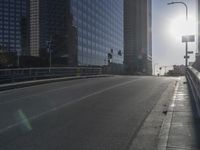 the sun is setting on a very big city skyline in the afternoon sun reflects off the glass windows and sidewalk
