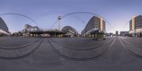 circular panorama mirror in city with tracks and traffic signals at a bus stop in the foreground