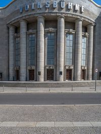 an entrance of a building with large columns and doors that spell out the word voltege