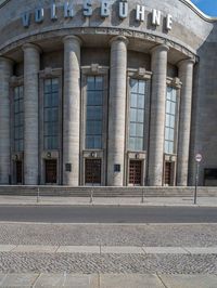 an entrance of a building with large columns and doors that spell out the word voltege