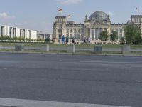 a person riding a skate board on the road by the german flag flying in the air