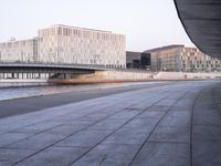 a wide river near a large building in a city area of a large city with a bridge