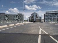 the asphalt roadway is almost empty in the daytime time and cloudy sky above the buildings