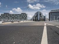 the asphalt roadway is almost empty in the daytime time and cloudy sky above the buildings