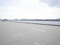 a boat is parked in an empty parking lot near an air port on the water